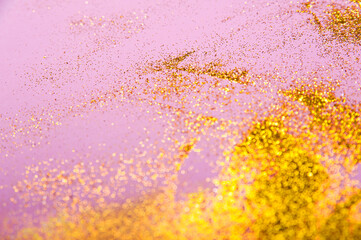 Gold sparkles on pink background and copy space. Trendy background for inscription with yellow confetti.
