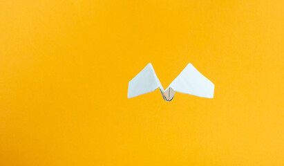 air flights mockup concept, blue paper airplane on a yellow background copy space.