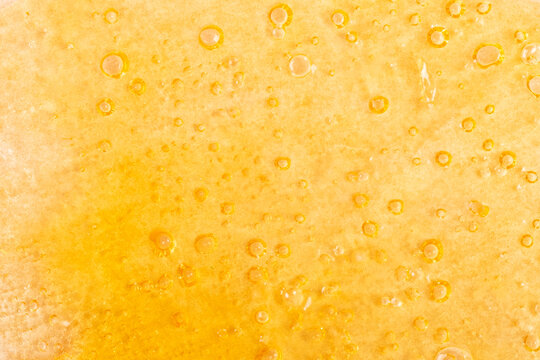 golden background of marijuana wax close-up, cannabis dab texture