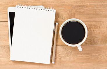 Fototapeta na wymiar digital tablet, notepad, pen and coffee mug on wooden table