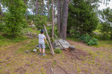 Beautiful view of child playing in forest on summer day. Sweden. 