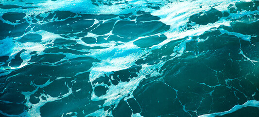 Beach and waves from the top. Turquoise background of sea water surface with top view. Summer seascape from the air on the sea waves. Top view from the drone. Travel concept and idea.