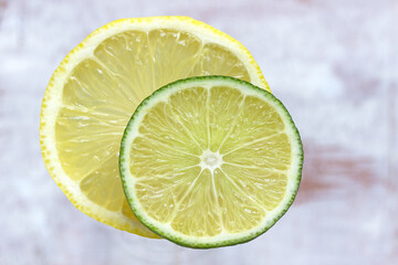 juicy lemon and lime slices overlapping together isolated on cloudy white backdrop