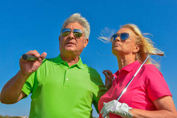 Close-up of active senior couple playing golf 