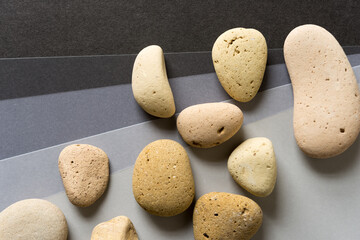 various stones on different shades of solid gray paper background