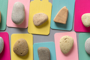 set of stones resting on pastel colored chalkboard tags - photographed from above with ambient light