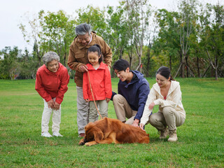 Happy family of five and pet dog playing in the park