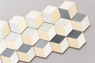 hand-painted (white and gray) trompe l'oeil (hexagonal) cubes on arranged on light gray paper background