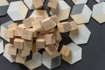 untreated wood craft cubes and painted trompe l'oeil (hexagonal) cubes on dark gray background