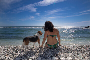 Fototapeta na wymiar girl with her dog on the sea shore