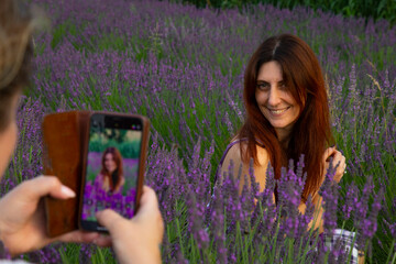 friends take photos with cell phones in the field of flowering lavender