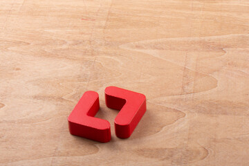 Pair of red bracket-shaped tiles on a wooden surface