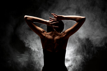 half silhouette modern ballet dancer posing on dark background with smoke - obrazy, fototapety, plakaty