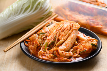 Kimchi cabbage on plate with chopsticks, Popular homemade Korean traditional fermented side dish...