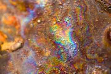 Abstract irridescent rainbow rusted orange and brown metal surface