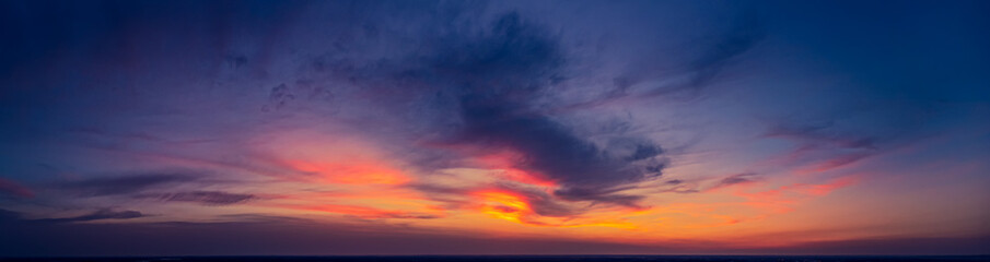 Naklejka na ściany i meble Dramatic panorama of late sunset with burning sky
