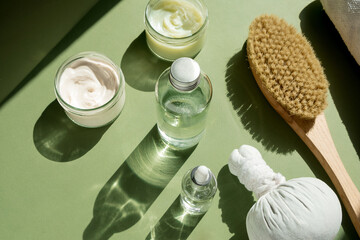 Body treatment and spa concept. Scrub, mask, cream and natural oil cosmetics on green background....
