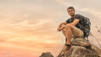 Naklejka na ściany i meble hiker sitting on rock for resting during walking on trekking trail