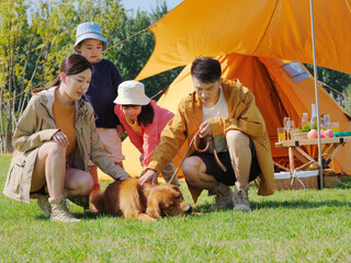 Fototapeta premium Happy family of four and pet dog in the park