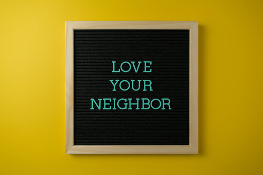 Love Your Neighbor Sign on Yellow Background
