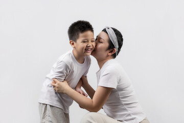 Young adult female cancer patient spending time with little son on gray background. Cancer and family support concept.