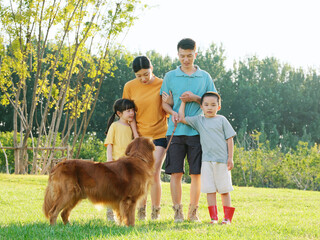 Happy family of four and pet dog in the park