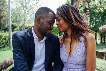 Pareja de novios africanos enamorados se dan besos y abrazos en un parque 