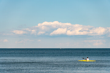 Naklejka premium Clouds and water lake Ontario. White blue small clouds on the sky near water coast in Toronto. Summer mood vibes. Sunny leisure after lock down. Relaxing background.
