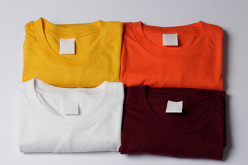 pile of colorful plain clothes. neatly arranged t-shirt mockup on a bright background. top view of...