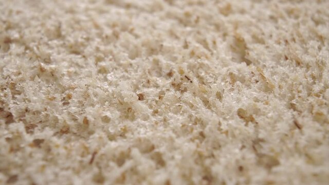 Rough texture of fresh wheat baked integral bread. Porous surface. Macro. Rotation