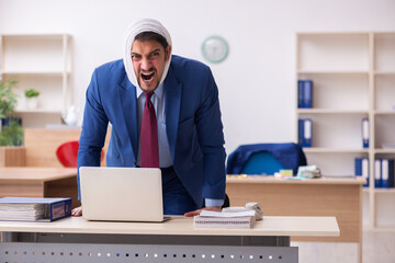 Young male employee suffering from toothache at workplace