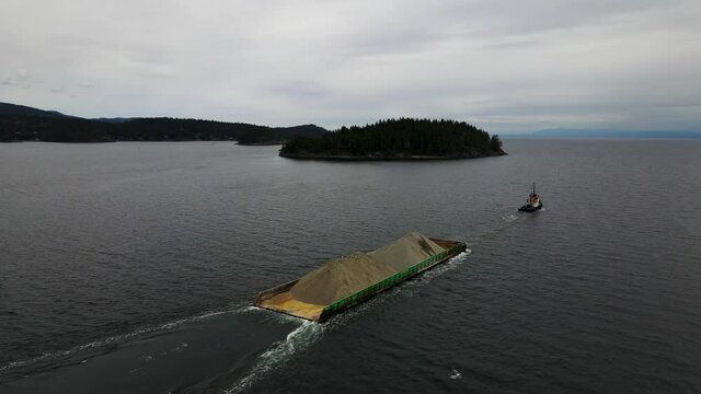 Aerial view of tug boat pulling sand in British Columbia