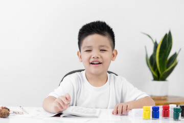 Happy little Asian kid at the table draw with watercolor Learning and education of kid.