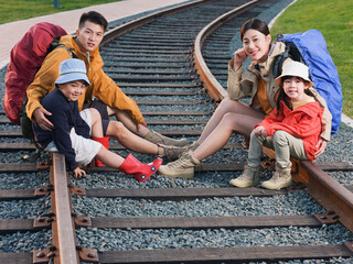 Happy family of four sitting on the track to rest