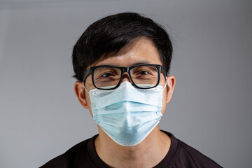 Asian mask looking over glass for prevention virus covid-19.