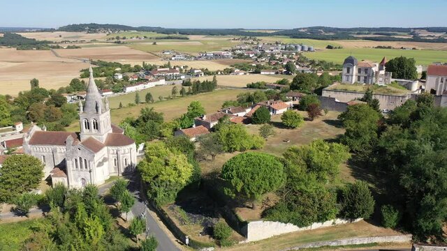 Drone view of medieval chateau and church in French village of Villebois-Lavalette on sunny summer day