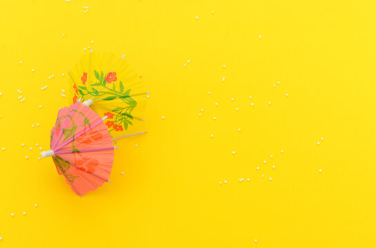 Paraguas de coctel sobre fondo amarillo.
