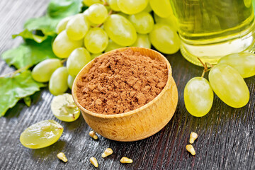 Flour grape seed in bowl on dark wooden board