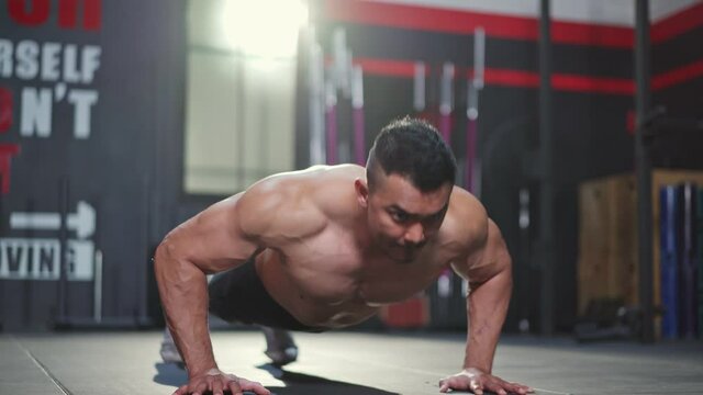 Asian Muscular Bodybuilder man push up exercise to build muscle in gym