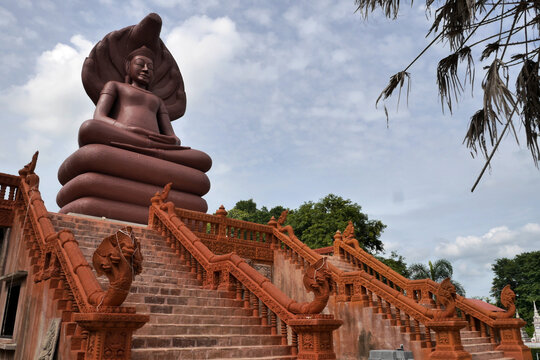 Stairway leading up to a Terracotta Buddha at Wat Khao Kradong, Mueang, Buriram, Thailand. against a blue sky....
