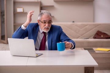 Fototapeta premium Old male employee working from home during pandemic