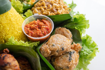 nasi tumpeng. indonesian cuisine yellow rice on banana leaf for celebration