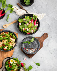 Freshly made salads on light gray background. Seasonal food concept.