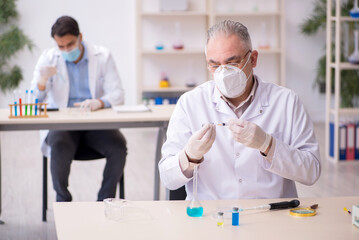 Two male chemists working at the lab during pandemic