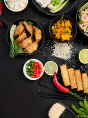 Assorted asian dishes and snacks on black background. Traditional food concept.