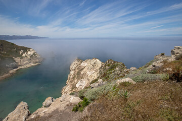 Potato Harbor on Santa Cruz Island with mist coming in under blue cirrus sky in the Channel Islands National Park offshore from Santa Barbara California USA