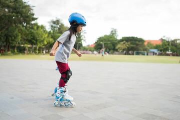 smiling 5 year old asian girl going on her in-line skates