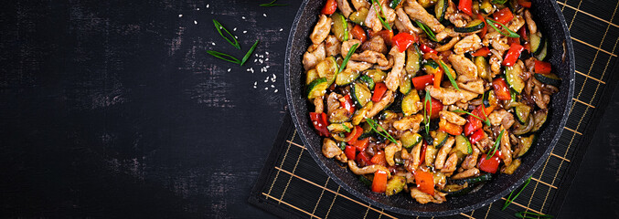 Stir fry with chicken, zucchini and sweet peppers - Chinese food. Top view, banner