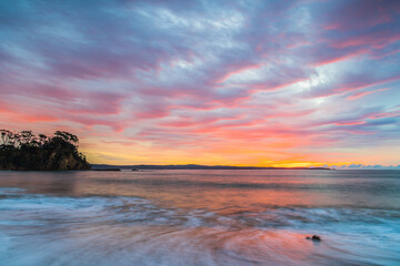 Obraz na płótnie Canvas Cloud covered sunrise seascape tinged with pink