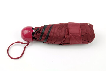 Dark red foldable umbrella on white compact, easy to carry